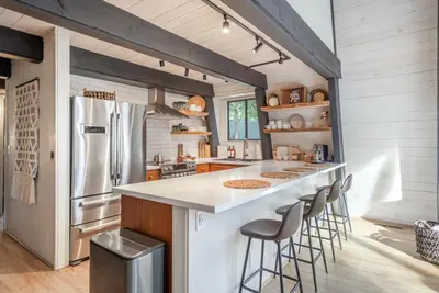 a kitchen with a white counter and a refrigerator at Mid Century Modern A-Frame Cabin at Northstar in Truckee