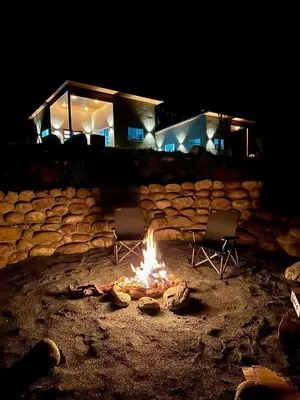 two chairs sitting around a fire in front of a building at Muniz Village in Three Rivers