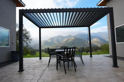 a table and chairs on a patio with a view of mountains at Muniz Village in Three Rivers