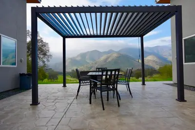 a table and chairs on a patio with a view of mountains at Muniz Village in Three Rivers
