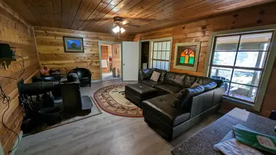 a living room with leather furniture in a log cabin at Baltyr Cabin in Miramonte
