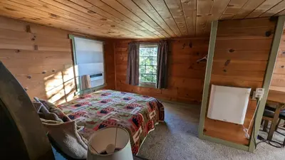 a bedroom with a bed in a wooden cabin at Baltyr Cabin in Miramonte