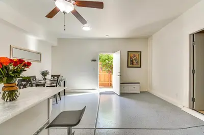 a living room with white walls and a ceiling fan at 10 Mi to Yosemite Lake Atwater Retreat in Atwater