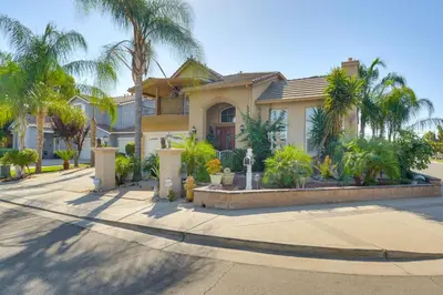 a house with palm trees in front of a street at 10 Mi to Yosemite Lake Atwater Retreat in Atwater