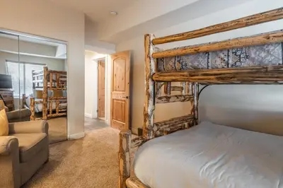 a bedroom with a bunk bed and a couch at Mammoth Gateway Village #1 - Highly Updated Townhome - Walk To Village 3 Bed+Loft, Sleeps 10 in Mammoth Lakes