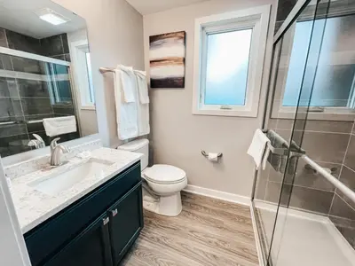 a bathroom with a toilet and a sink and a shower at Beautiful and Elegant River Front Cottage in Reno