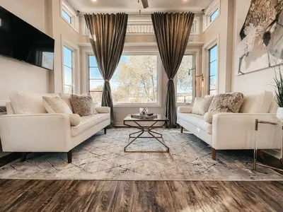 a living room with two white couches and a table at Beautiful and Elegant River Front Cottage in Reno
