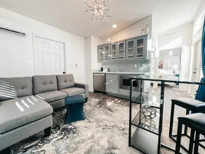 a living room with a couch and a table at Beautiful Courtyard Cottage Sapphire in Reno