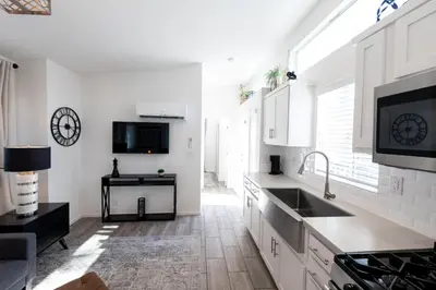 a white kitchen with a sink and a counter at Cottage on Historic Grounds Citrine in Reno