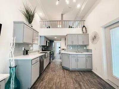 a kitchen with white cabinets and a large window at Beautiful Downtown Cottage Onyx in Reno