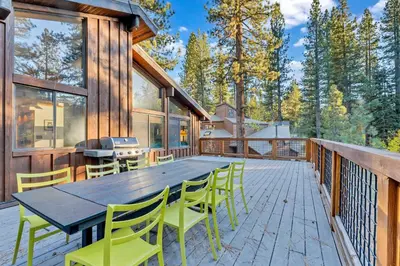 a deck with a wooden table and chairs on a house at Northstar Retreat with Hot Tub & FREE Shuttle Access in Truckee