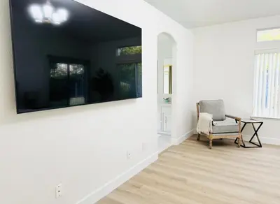 a living room with a chair and a large painting on the wall at Charming Retreat in CA Valley in Fresno