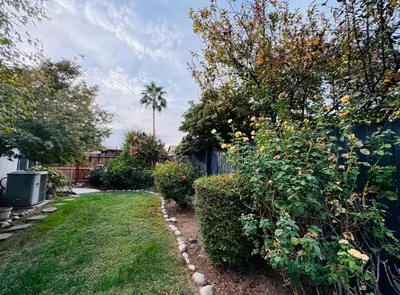 a garden with a fence and some bushes and trees at Charming Retreat in CA Valley in Fresno