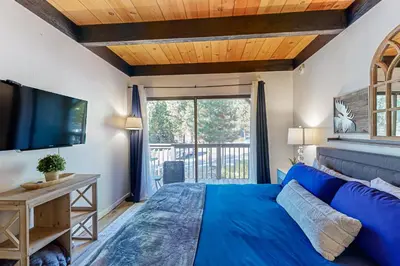 a bedroom with a blue bed and a large window at Inn at South Lake Tahoe in Kings Beach
