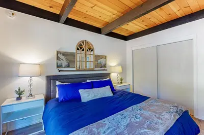 a bedroom with a blue bed and a wooden ceiling at Inn at South Lake Tahoe in Kings Beach