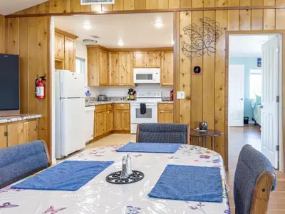 a kitchen with a table and chairs and a white refrigerator at Yosemite Mountain Top - Treetop Villa in Mariposa