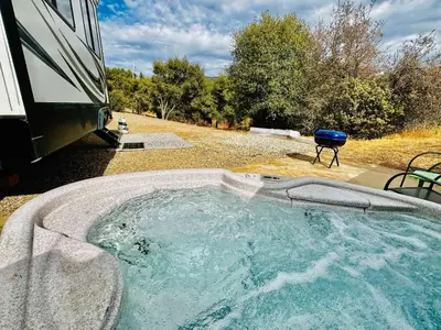 a large hot tub in front of a truck at Puffy Panda RV-Hot Tub-Sleeps 2 in Ahwahnee
