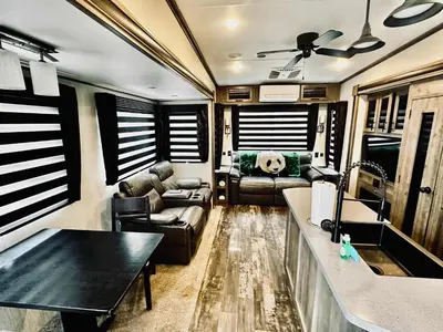 a living room with a couch and a table at Puffy Panda RV-Hot Tub-Sleeps 2 in Ahwahnee