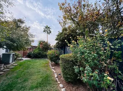a garden with bushes and trees and a fence at Charming retreat in CA Valley in Fresno