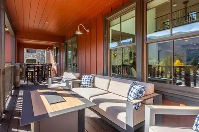 a porch with a couch and tables and windows at Creekhouse 1374 in Mammoth Lakes