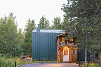 a tiny house in the woods with a garage at The Calder Cabin in Soda Springs