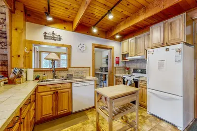 a kitchen with wooden cabinets and a white refrigerator at The Calder Cabin in Soda Springs
