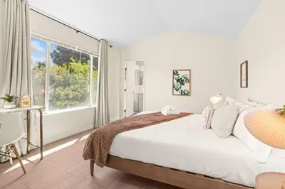 a bedroom with a large bed and a large window at Remodeled 3B2B Bright House with a King Suite in Sacramento