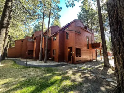 a wooden house in the woods with trees at Winterset #33 condo in Mammoth Lakes