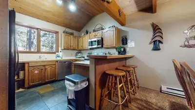 a kitchen with wooden cabinets and a counter with stools at Winterset #33 condo in Mammoth Lakes