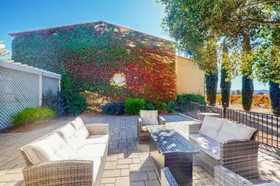 a patio with white couches and chairs in front of a building at Morgan Hill Couples Gem Villa in the Vineyards in Morgan Hill