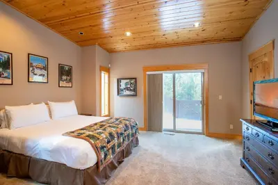 a bedroom with a bed and a flat screen tv at Hillside Mountain Creek Haven home in Truckee