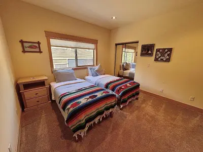 a bedroom with two beds and a window at Hillside Mountain Creek Haven home in Truckee