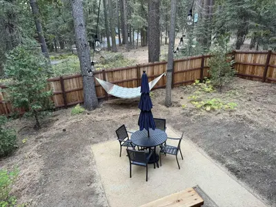 a table and chairs with a hammock in a backyard at Tahoe West Shore Escape in Tahoe City