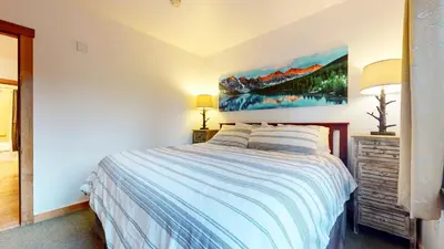 a bedroom with a bed and a painting on the wall at Juniper Springs Lodge #246 condo in Mammoth Lakes