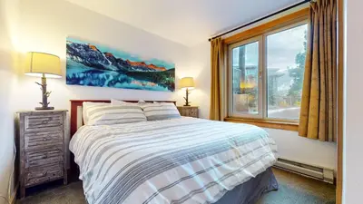 a bedroom with a bed and a large window at Juniper Springs Lodge #246 condo in Mammoth Lakes