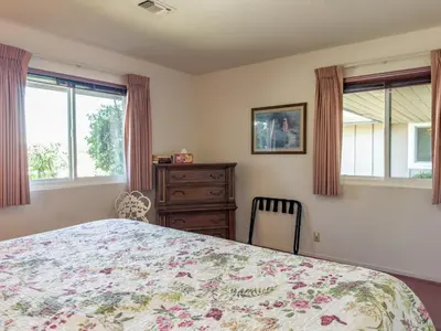 a bedroom with a bed and a dresser and windows at Yosemite Mountaintop Retreat on 100 acres, 2 Homes, 2 hot tubs, pool in Mariposa