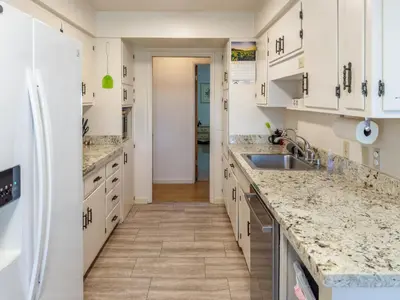 a kitchen with white cabinets and marble counter tops at Yosemite Mountaintop Retreat on 100 acres, 2 Homes, 2 hot tubs, pool in Mariposa