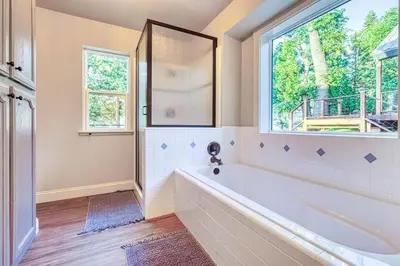 a bathroom with a large tub and a window at Sunset Retreat AC, Big Views & Dream Deck in Shaver Lake