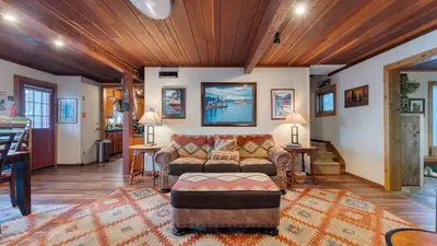 a living room with a couch and a table at Lakefront Haven by AvantStay Minutes to Ski Resorts Private Dock in Homewood