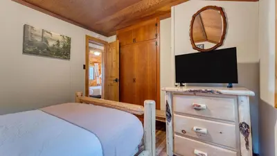 a bedroom with a bed and a tv on a dresser at Lakefront Haven by AvantStay Minutes to Ski Resorts Private Dock in Homewood