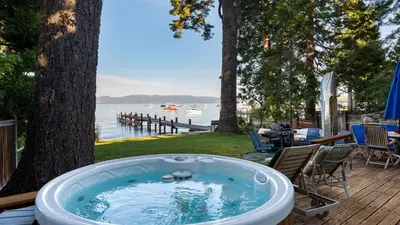 a jacuzzi tub sitting on a deck next to a tree at Lakefront Haven by AvantStay Minutes to Ski Resorts Private Dock in Homewood