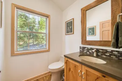 a bathroom with a sink and a mirror at Knotty and Nice - 4BR w Private Hot Tub, Close to Lake in Tahoe Vista