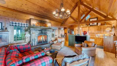 a living room with a couch and a fireplace at Homewood Lakefront by AvantStay Private Beach Lake Access Views in Homewood