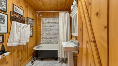 a bathroom with a sink and a bath tub and a toilet at Homewood Lakefront by AvantStay Private Beach Lake Access Views in Homewood