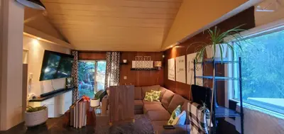 a living room with a couch and a large window at Secret Oasis in Sacramento! in Sacramento