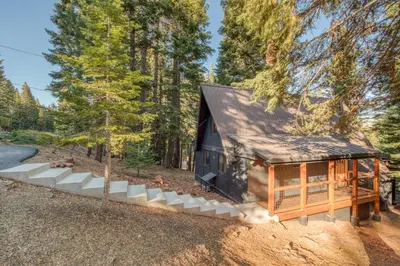a cabin in the woods with a black roof at A-Frame of Mind in Tahoe Donner - Pet-Friendly 2 BR 1 BA with Pool Table in Truckee