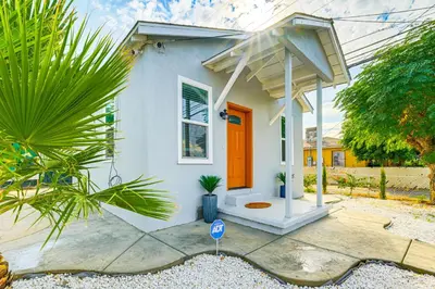 a small white house with an orange door at Small-Town Charm and Patio Dining Home in Madera! in Madera