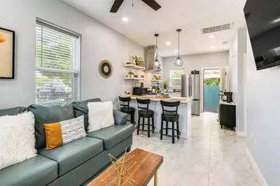 a living room with a blue couch and a kitchen at Small-Town Charm and Patio Dining Home in Madera! in Madera