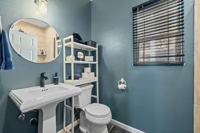 a bathroom with a toilet and a sink and a mirror at Zen Whisper in the Woods in Groveland