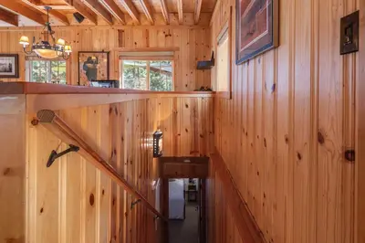 a hallway in a wooden cabin with a wooden staircase at Home for 10 Private Hot-Tub Close to Ski Private Beach Access w Double Decker pier Book on Mobile for Promo Price in Carnelian Bay